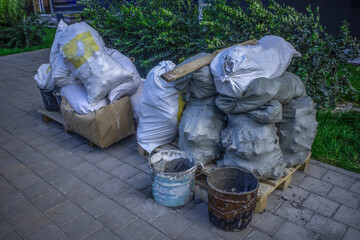 Construction debris in bags on the sidewalk on a summer day