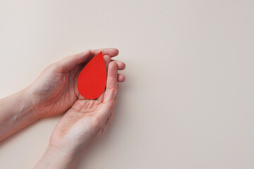 Hands Holding a Red Blood Drop Donation and Healthcare Concept