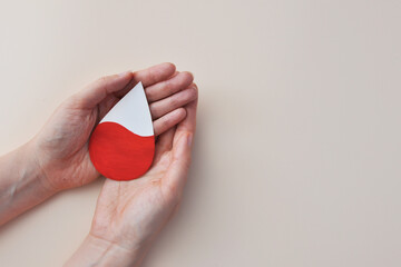Hands Holding a Red Blood Drop Donation and Healthcare Concept