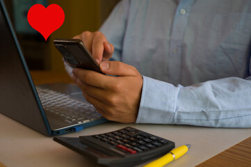 Businessman using smartphone and laptop in office. Man scrolls social media, checks email, manages...
