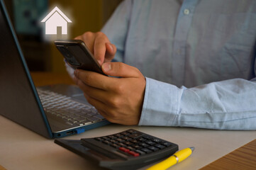 Businessman using smartphone and laptop in office. Man scrolls social media, checks email, manages...