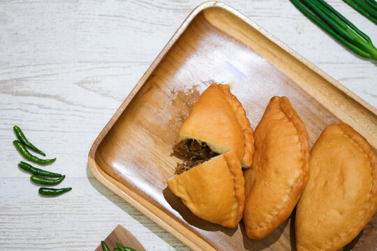Panada. Is a typical culinary specialty of Manado, North Sulawesi, which is soft fried bread stuffed with spicy skipjack tuna pampis. Flatlay