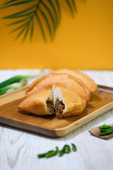 Panada. Is a typical culinary specialty of Manado, North Sulawesi, which is soft fried bread stuffed with spicy skipjack tuna pampis. Flatlay