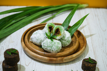 Onde - Onde.Traditional cakes from Manado, North Sulawesi, Indonesia. Made with sticky rice flour, a coating of delectable grated coconut, and a filling of brown sugar that melts in your mouth.flatlay