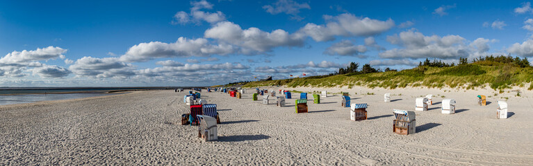 Panorama &uuml;ber den menschenleeren Strand von Utersum mit Strandk&ouml;rben auf der nordfriesischen Insel F&ouml;hr