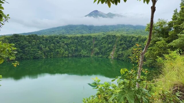 Tolire Besar Lake, Ternate, North Mollucas, Indonesia. Beautiful Green Lake in below ground level with Gamalama Mountain in the background. Vertical