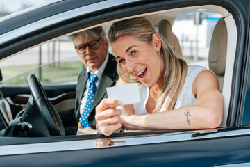 Proud woman celebrates passing her driving test and getting her first official license