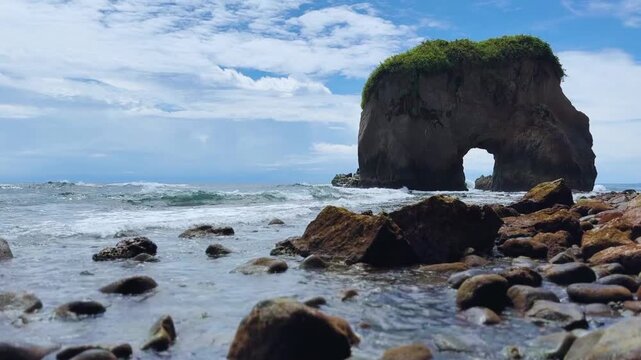 A striking hollow rock formation on a beach by the ocean in Hiri Island, Ternate, North Mollucas, Indonesia.