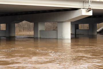 Main road bridge. River flowing through the bridge during spring flood