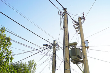 View of utility poles with transformer and lots of wires. Concept of engineering complexity,...