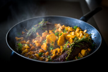 healthy lifestyle - roasted chanterelles and filet from venison with fresh herbs out the garden 