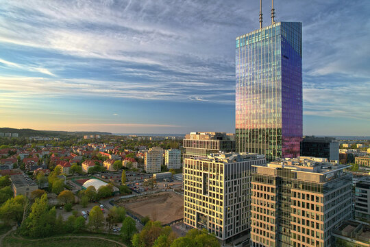 Close aerial view of Olivia Star skyscraper reflecting colorful sunset light