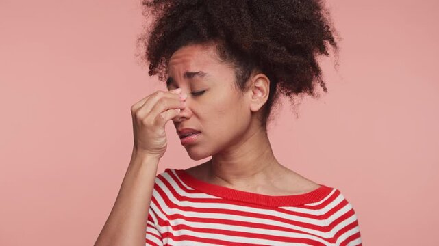 Young woman touching face in sinus pain discomfort on pink