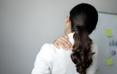 Fototapeta premium Woman having shoulder pain pain during work long time. stretching to relax and relax while working hard at the office