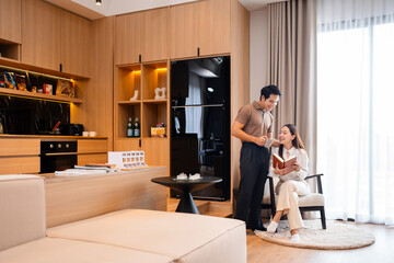 Couple reading books and drinking coffee while resting together at home .