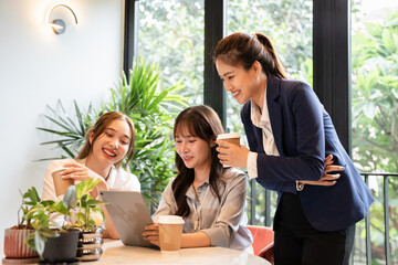 Three businesswomen in office, enjoying a coffee break and engaging in friendly conversation,...