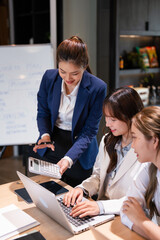 Confident youg businesswoman teaching interns or helping new employees in the organization, using...