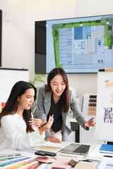 Two young asian female interior designer or architect working on creative project with drawing,...