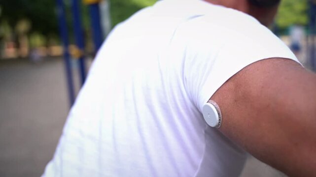 Man with glucose monitoring sensor doing push-ups 
