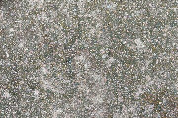Concrete texture. Pebbles of different colors and signs of aging are visible.