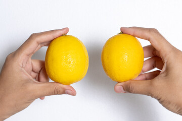 Hands Holding Fresh Lemons Against a White Background