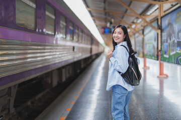 Young woman waiting for train at railway station