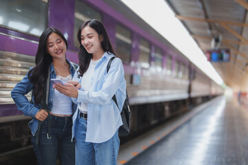 Young women using smartphone on train station platform