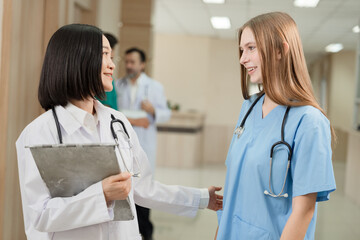 Major Asia doctor woman working and talking with Caucasian woman medical student at hospital	
