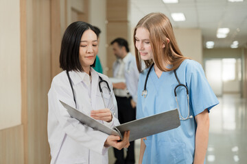 Major Asia doctor woman working and talking with Caucasian woman medical student at hospital	