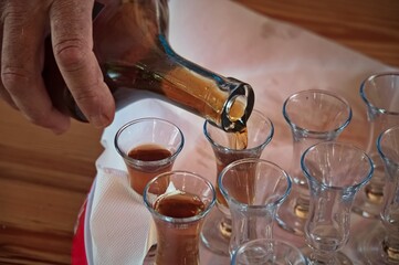 Midsection of man pouring brandy from a bottle