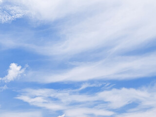 Bright blue sky with soft fluffy clouds on a summer day. Blue sky with clouds. Soft white clouds float in the clear blue sky. Clear blue sky, bright spring, soft sky gradient.