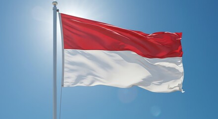 The national flag of Indonesia waving proudly in the wind against a bright blue sunny sky.