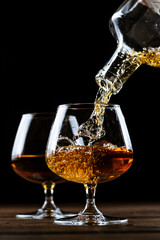 Cognac is poured into a glass from a bottle.