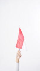 A woman hand holding mini Indonesia flag attribute decoration to celebrate Indonesia independence day celebration isolated on white background