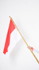 A woman hand with red and white Indonesia flag color attribute holding Indonesia flag to celebrate Indonesia independence day celebration isolated on white background