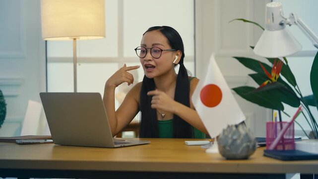 Young woman teaching Japanese language course online via laptop, remote lesson