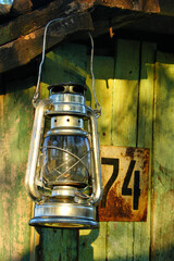 Vintage Kerosene Lantern Hanging on Rustic Wooden Wall with Number 74 Sign