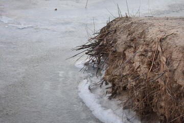 ice and snow on sandy beach in winter, closeup of photo