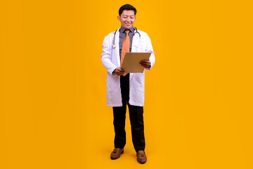 Asian Man Doctor Reviewing Patient Records On a Clipboard