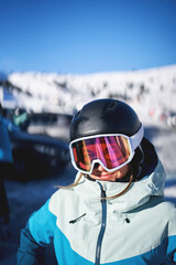 Smiling woman wearing ski goggles and helmet in snowy landscape