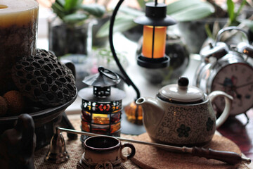 Cozy Still Life with Teapot, Lanterns, and Candle on Rustic Tabletop