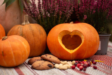 Carved Pumpkin with Heart Cutout and Autumn Snacks