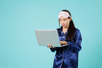 Angry woman remote work on laptop computer, overworked in pajamas, she wants to sleep instead of...