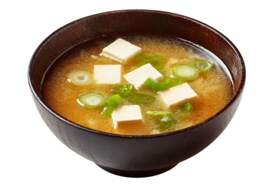 On transparent background a closeup shot of a steaming bowl of japanese miso soup filled with cubes of tofu and