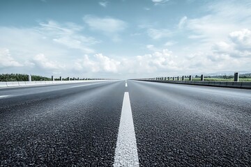 Naklejka premium Empty highway with white line vanishing point perspective, bright cloudy sky, asphalt road