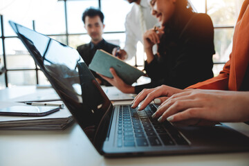 Portrait of a secretary typing information during a meeting in a conference room.