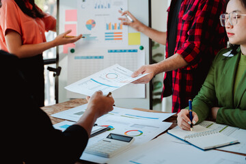 Brainstorming of young modern group. Team meeting to achieve goal. Business people discussing finance business and analysis. Teamwork concept in modern office. Calculating personal tax for client.