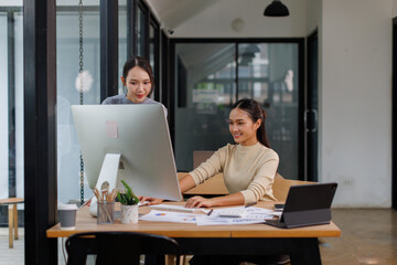 Asian project manager uses laptop displayed data analysis while professional business team brainstorming marketing idea at business meeting. Working together,sharing idea, planing strategy. 