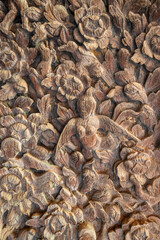 Traditional Thai wood carving of a kinnari surrounded by flowers. The fine details and natural texture highlight the beauty of ancient craftsmanship and cultural storytelling.