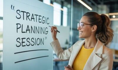 Smiling woman writing "Strategic Planning Session" on glass board